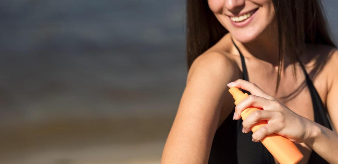 smiley-woman-applying-sunscreen-beach (1)